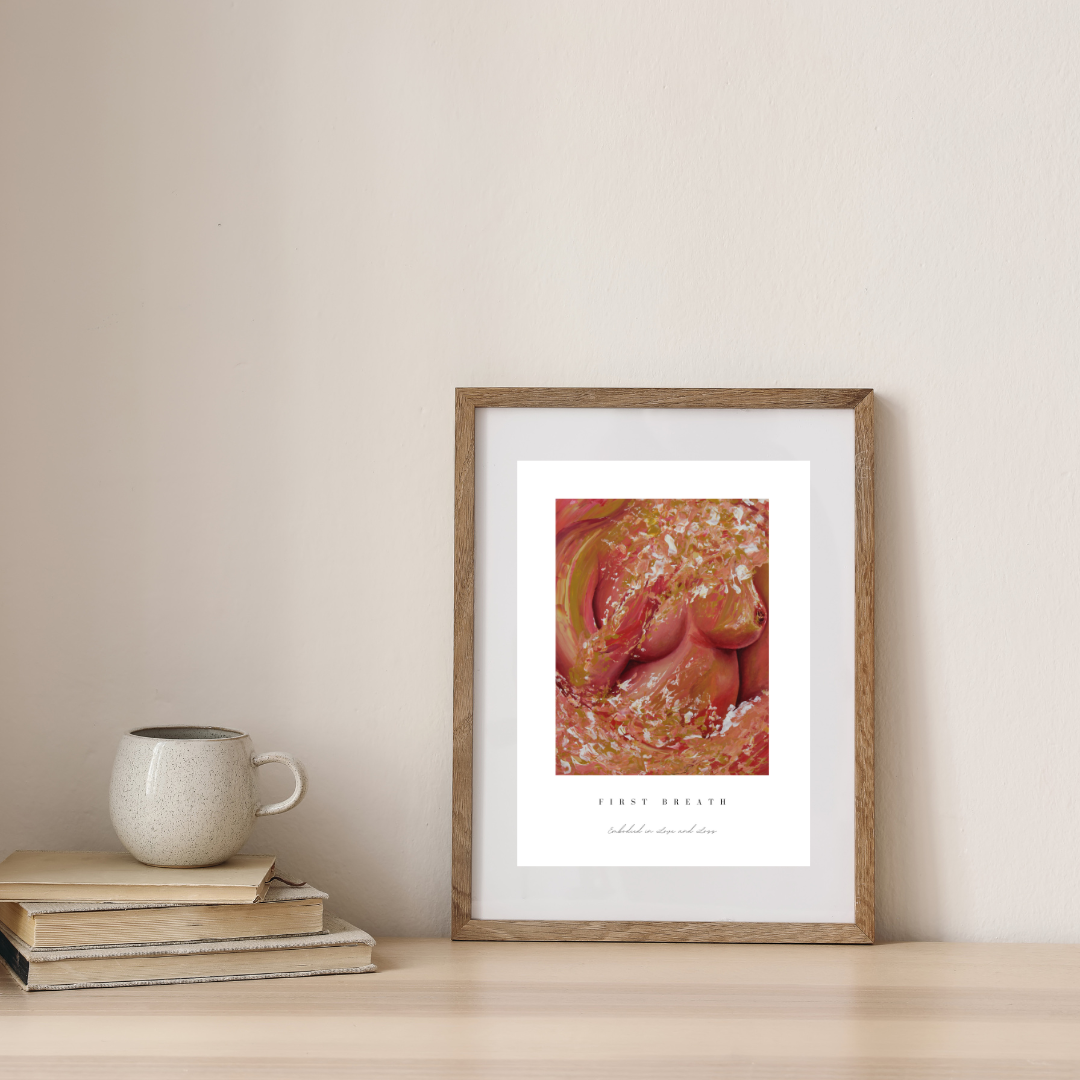 Framed artwork on a wall next to books and a mug