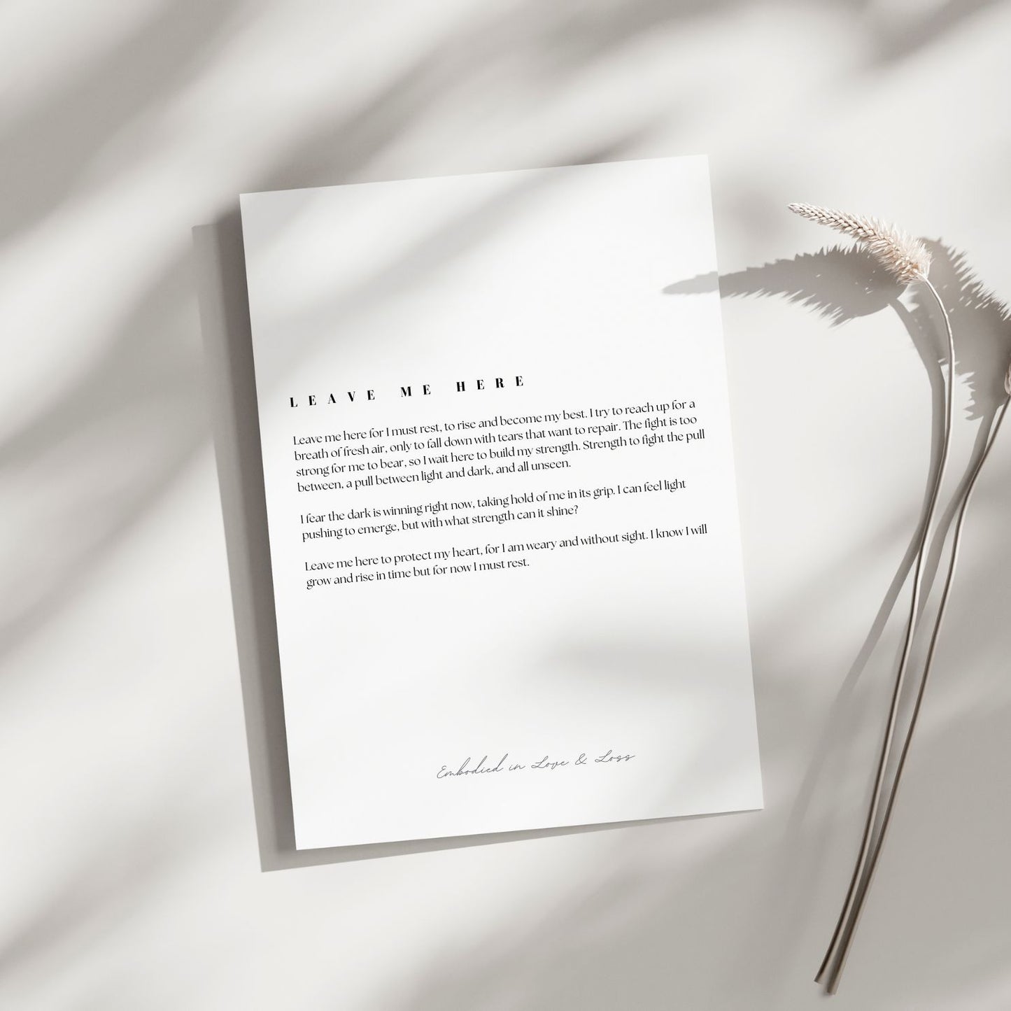 Sheet of paper with text on a light background with dried plants