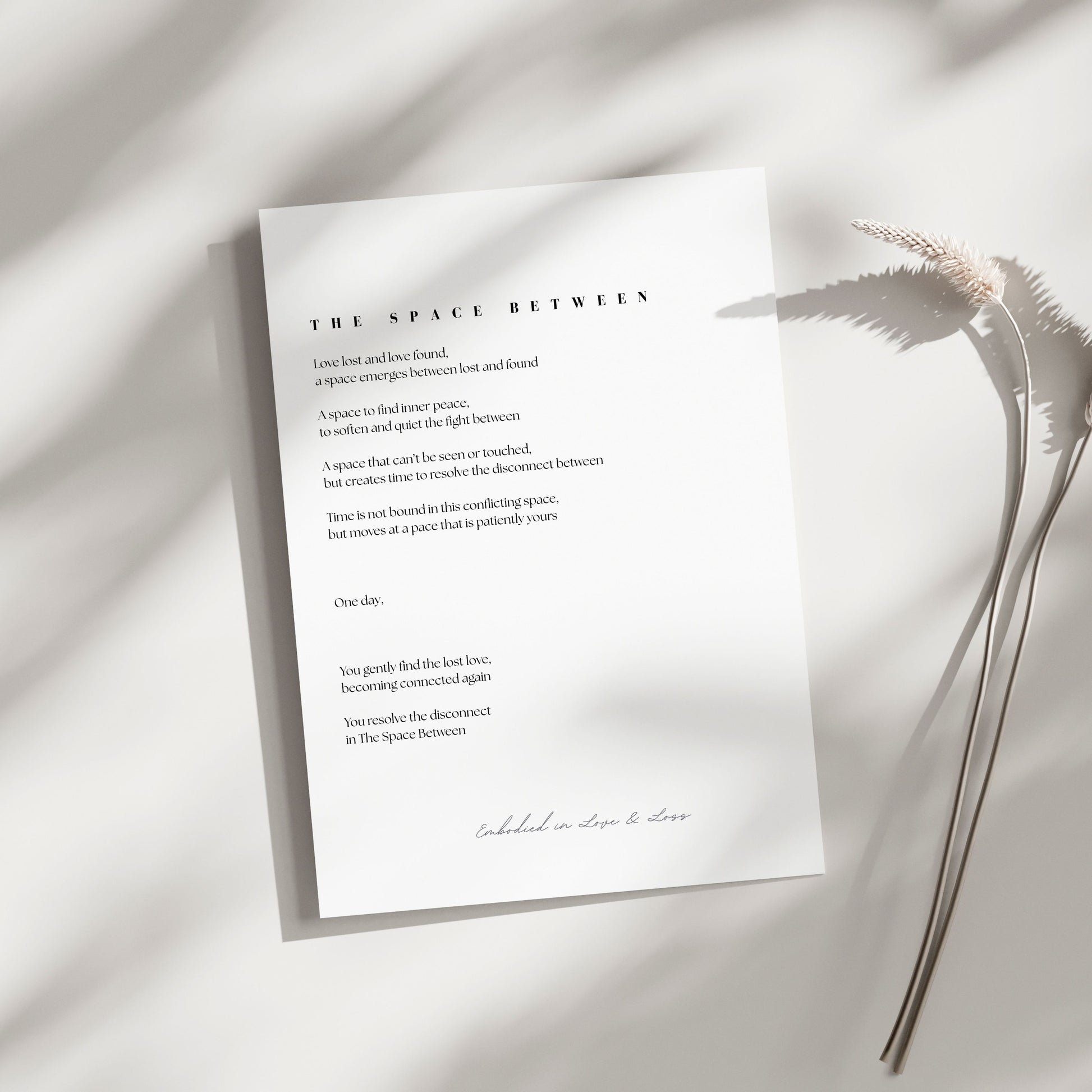 Sheet of paper with text on a light background with a plant leaf