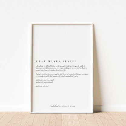 Framed text art print on a white wall with wooden floor.